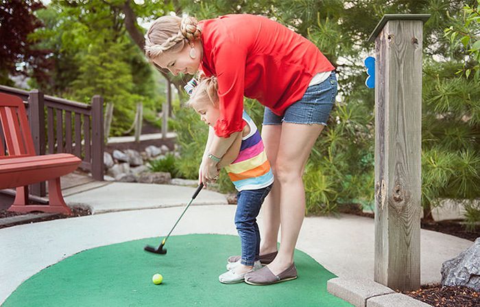 A child and their baby playing mini golf at Bird-in-Hand Family Inn